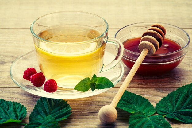 Glass cup of green tea with a saucer and the slice of lemon