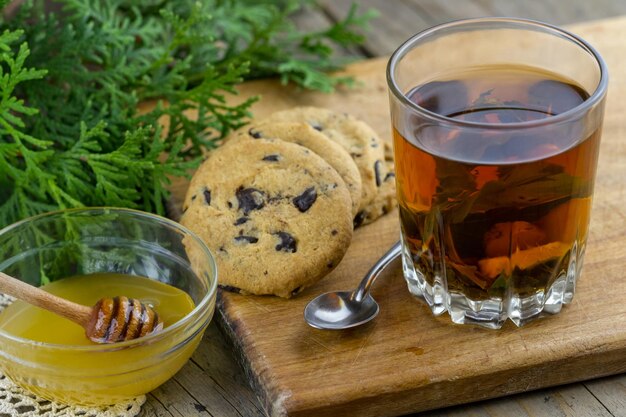 Foto un bicchiere di tè alla menta e biscotti con miele sul tavolo.