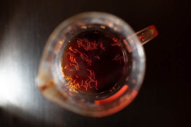 Glass cup of rooibos tea on wooden table.