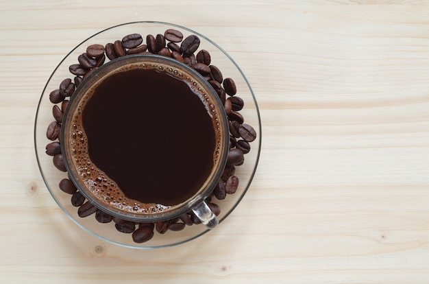 Glass cup of tasty coffee and beans on the table