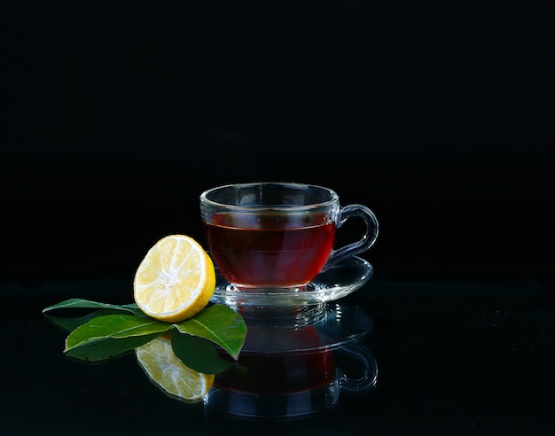 Glass cup of tea on black.