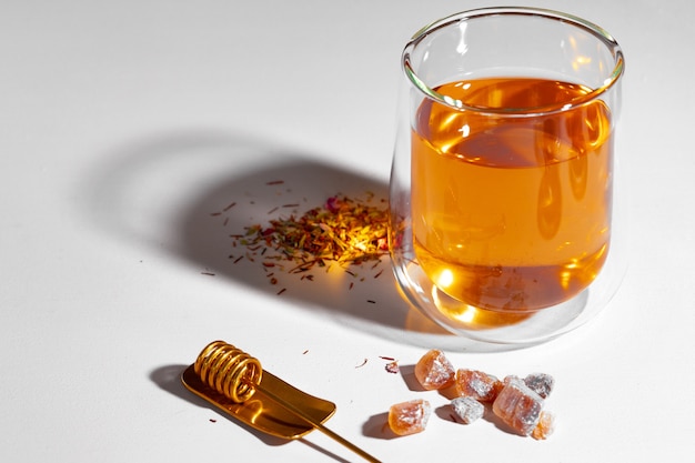 Glass cup of tea on blue background with shadow