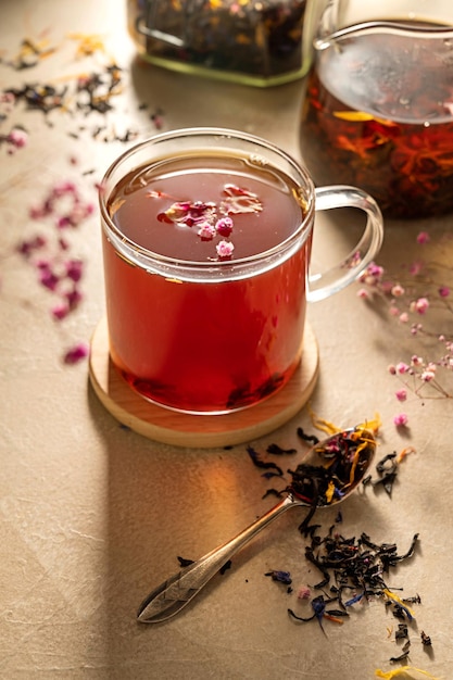 A glass cup of tea with a flower on it