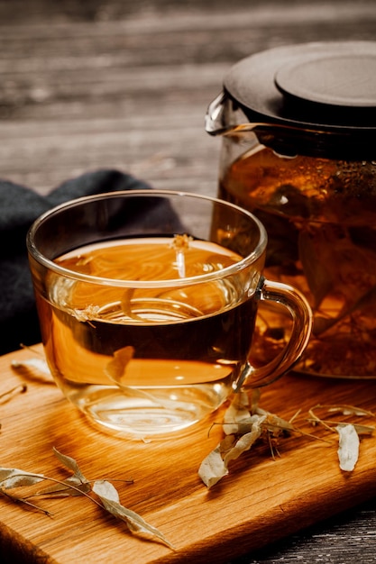 Tazza di tè in vetro con tiglio su tavola di legno