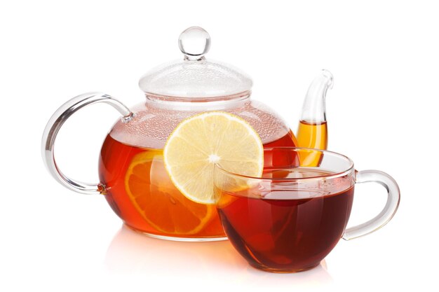 Glass cup and teapot of black tea with lemon