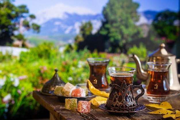 Glass Cup of turkish tea served in traditional style with summer outdore view