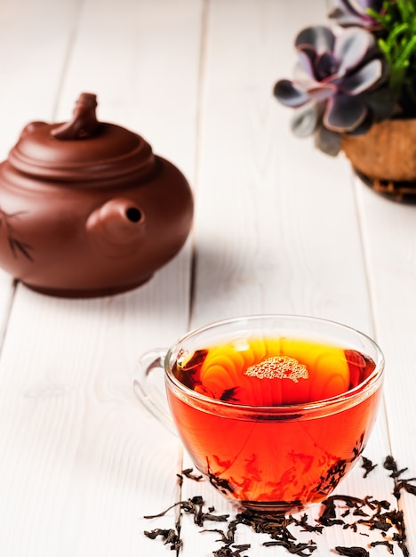 Glass cup with red tea and teacup