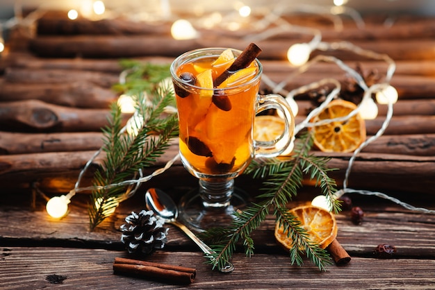 Glass cup with tea and fruit on a wooden surface