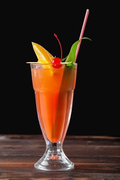 Glass of delicious alcoholic cocktail on dark background