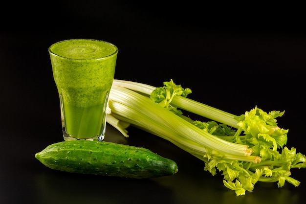 Glass of delicious green cucumber and celery smoothie on black background close up