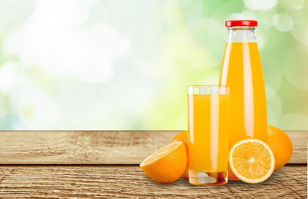 Glass of delicious orange juice on natural background