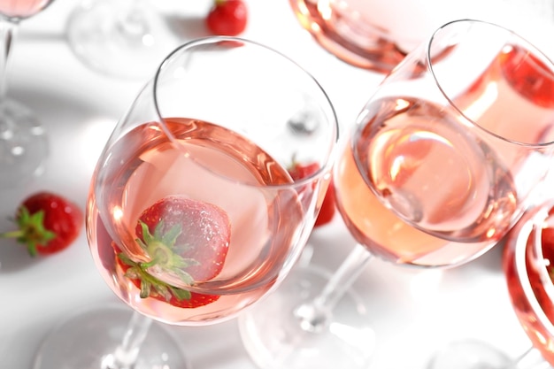 Glass of delicious strawberry wine on white background