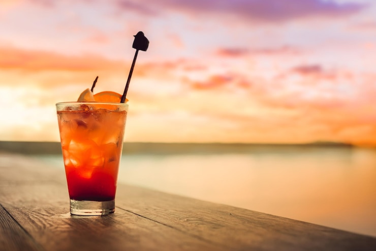 Photo glass of drink on table at sunset
