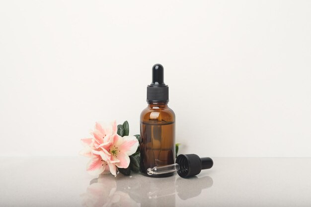 A glass dropper bottle on the beige background