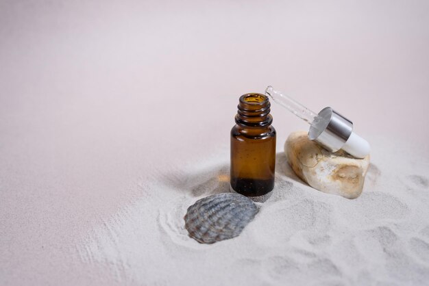 A glass dropper bottle on the pink background