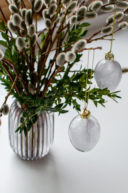 Glass eggs with feathers among willow and mistletoe branches