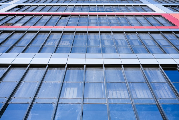 Glass facade of a house against a blue sky bottom view