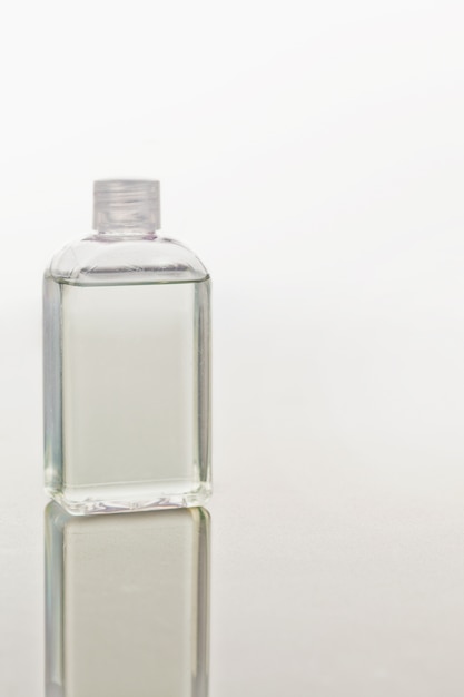 Photo glass flask on a mirror against white background