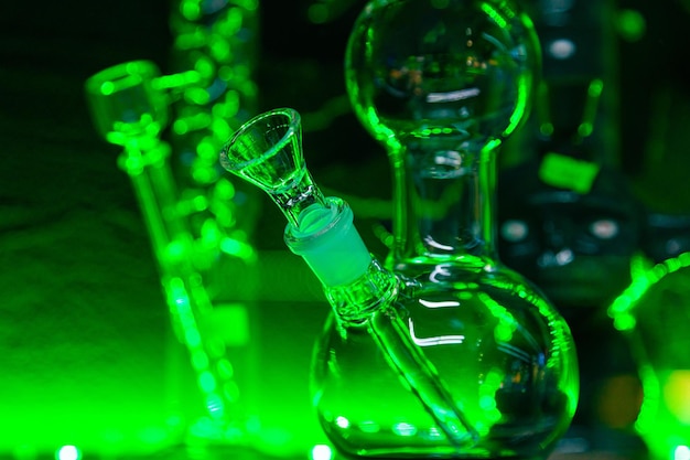 Glass flasks for smoking marijuana herb under green lighting Herb smoking device