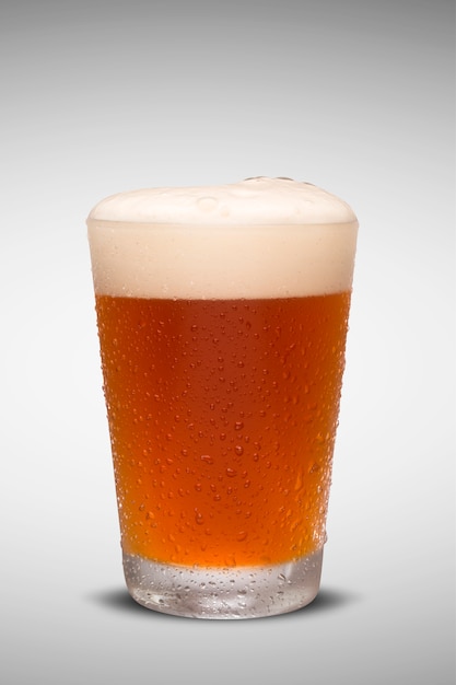 Glass of fresh beer with cap of foam isolated on white background