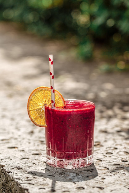 Glass of fresh berry smoothie with orange slice