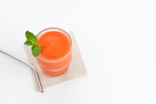 A glass of fresh carrot juice, very good for health. Served in glass on white background