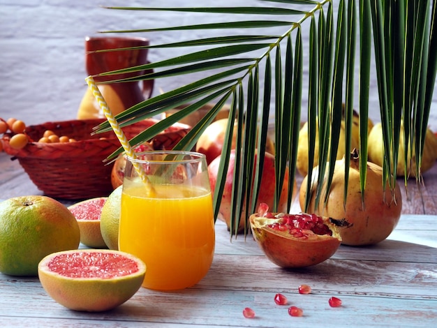 Glass of fresh citrus juice with fruits on a wooden table