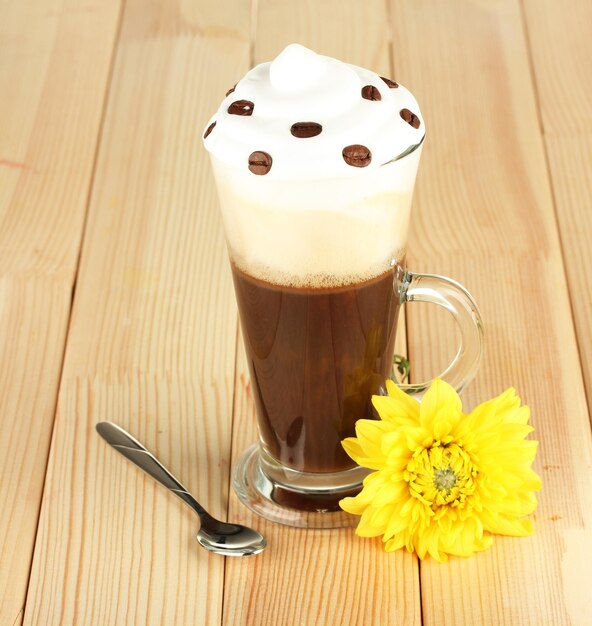 Glass of fresh coffee cocktail awith flower on wooden background