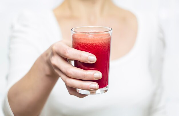 A glass of fresh juice in a hand.