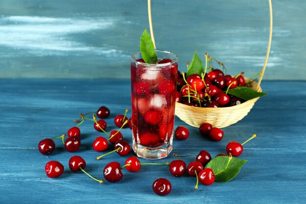 Glass of fresh juice with cherries on wooden table close up