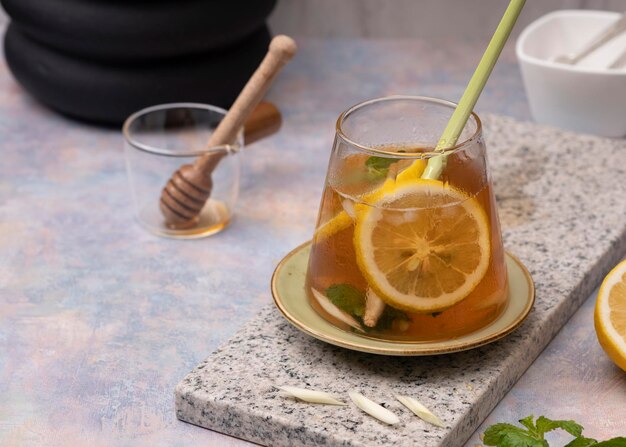 Glass of fresh lemon ice tea with lemongrass on white marble table. Selective Focus. Close Up