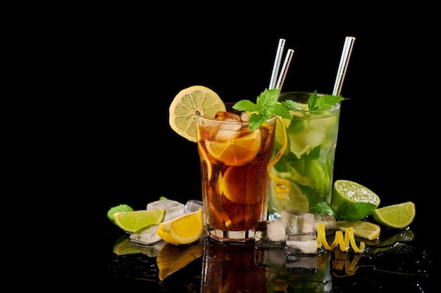 Glass of fresh long island ice tea and mojito cocktail  studio shot on black background