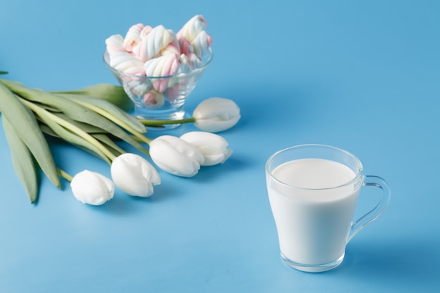 Glass of fresh milk and tulips