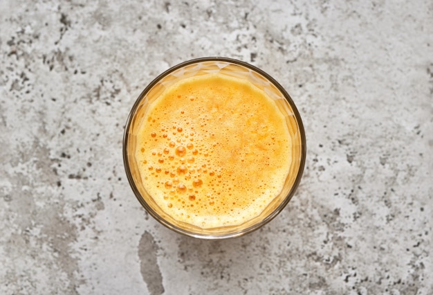 Glass of fresh orange juice on restaurant table, top view