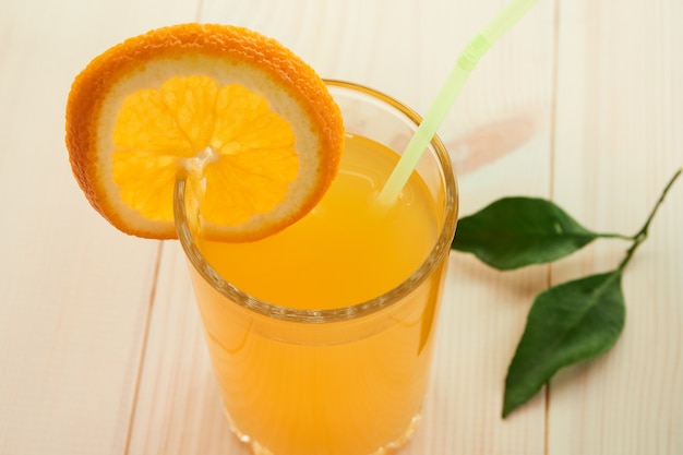 A glass of fresh orange juice and a slice of orange