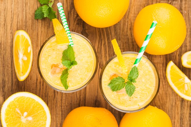 Glass of fresh orange juice with fresh fruits on wooden table