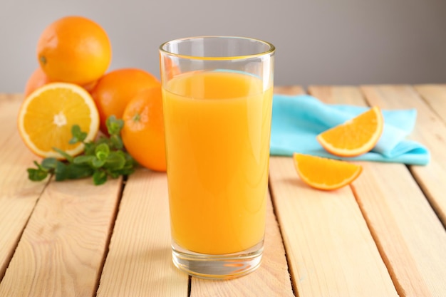 Glass of fresh orange juice on wooden table