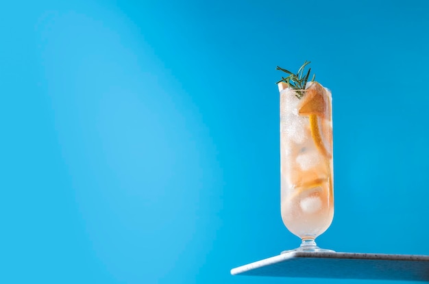 Glass of fresh paloma cocktail on bright blue background Spring summer art drink food concept