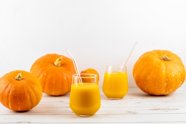 A glass of fresh pumpkin juice on a wooden table