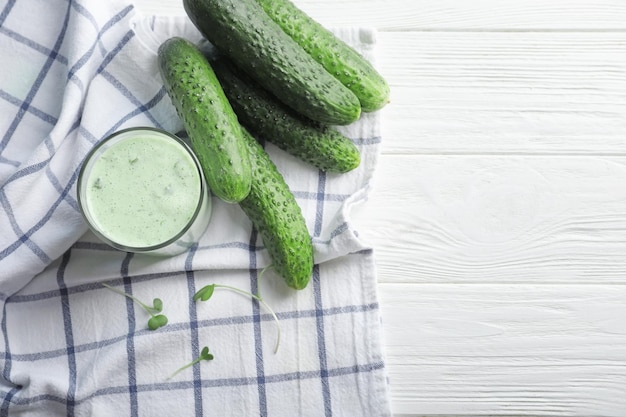 Glass of fresh smoothie with cucumbers on table