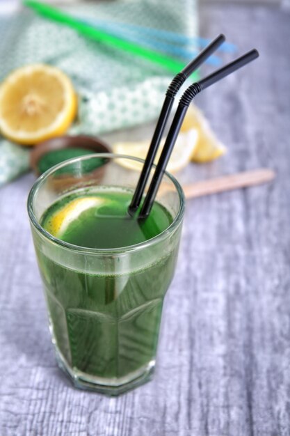 Glass of fresh spirulina drink on table