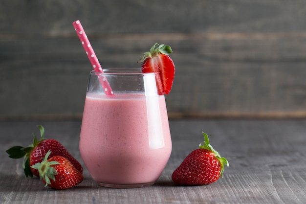 Glass of fresh strawberry milkshake, smoothie and fresh strawberries