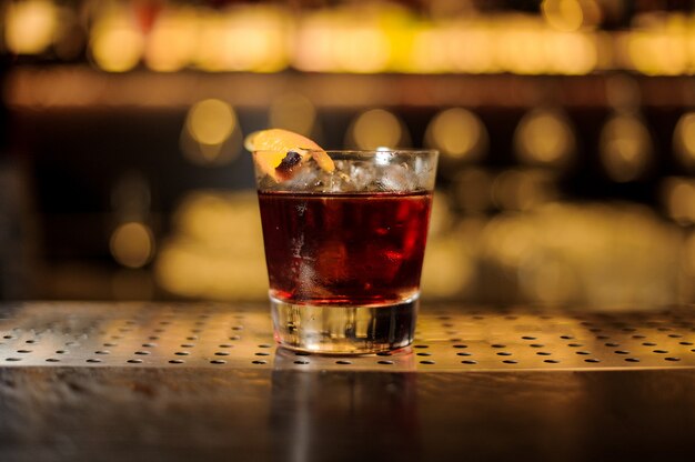 Glass of fresh and strong whiskey cocktail decorated with orange peel