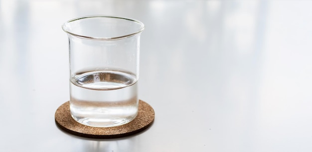 Glass of fresh water on white desk