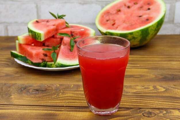 Glass of fresh watermelon juice on a wooden table