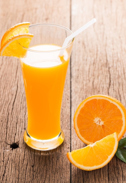 Glass of freshly pressed orange juice with sliced orange 