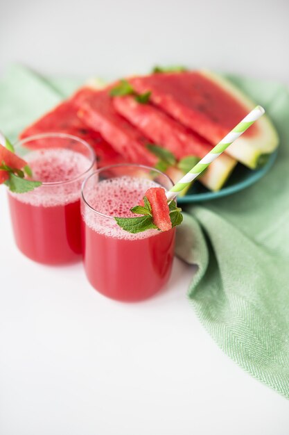 A glass of freshly squeezed fresh watermelon juice, a healthy watermelon and mint leaf smoothie.