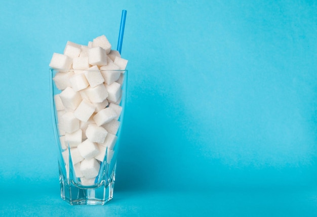 Glass full of sugar cubes addiction calories carbohydrates caries children cola