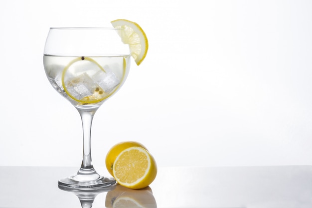 Photo glass of gin tonic with lemon isolated on white