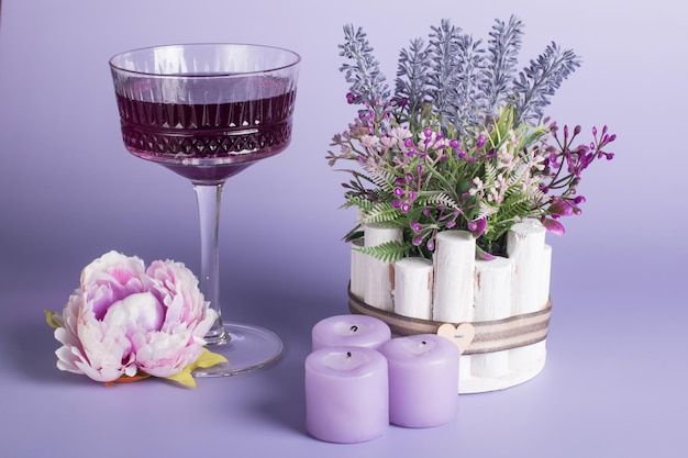 A glass glassa creamer for drinks with colored drinks Alcoholic fruit cocktail on a wooden background with candles the concept of relaxation